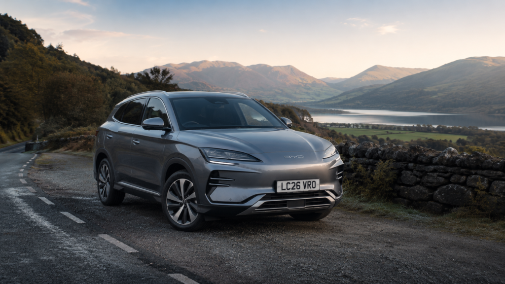 A silver family vehicle driving smoothly on an open scenic highway road