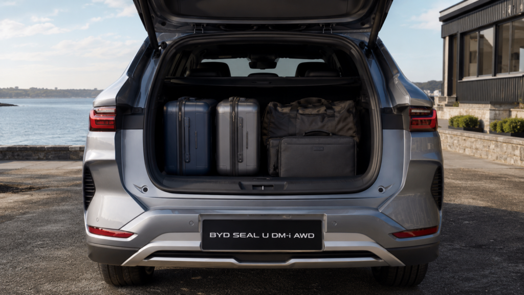 Open vehicle luggage boot space loaded with clean travel suitcases and gear